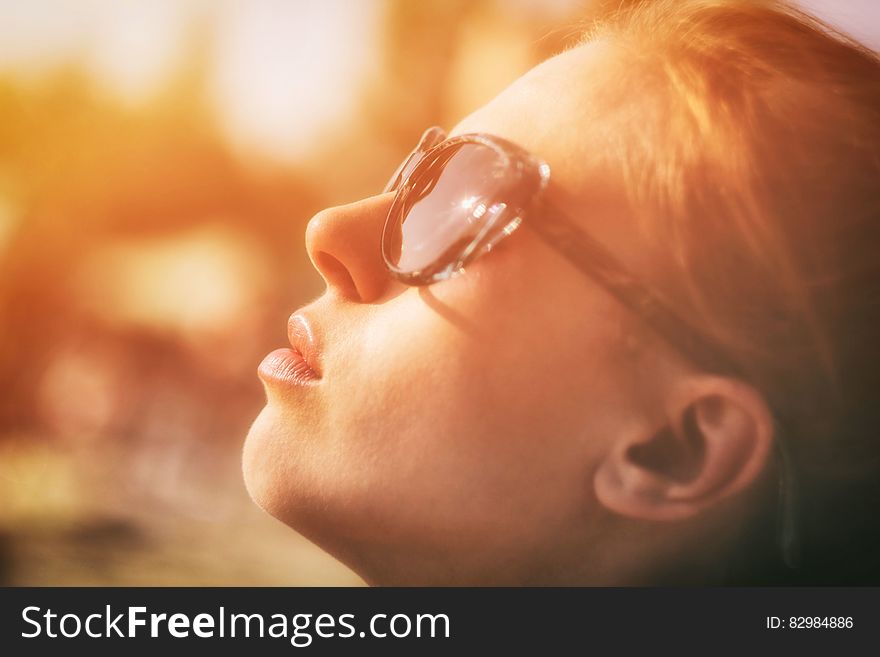 Closeup portrait of girl with red hair and wearing spectacles looking up as if in prayer and bathed in a golden glow. Closeup portrait of girl with red hair and wearing spectacles looking up as if in prayer and bathed in a golden glow.