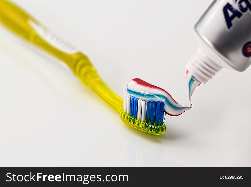 Toothpaste Being Put on Yellow Toothbrush