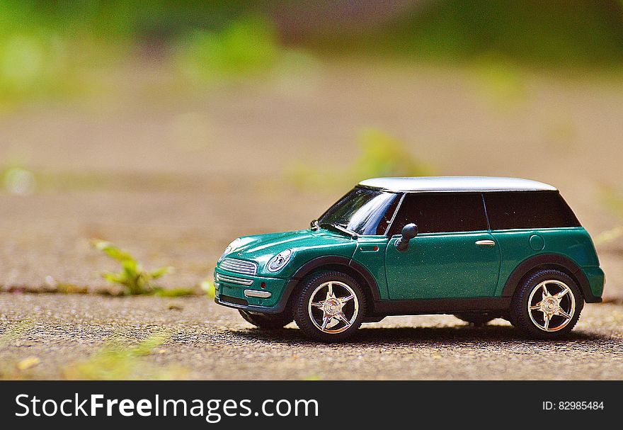 Green Scale Model Car on Brown Pavement