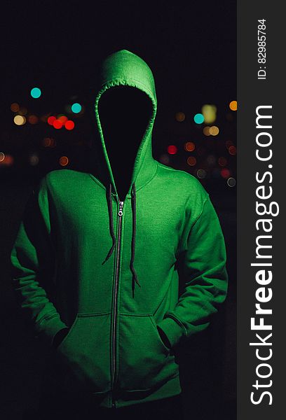 Faceless person in green hoodie