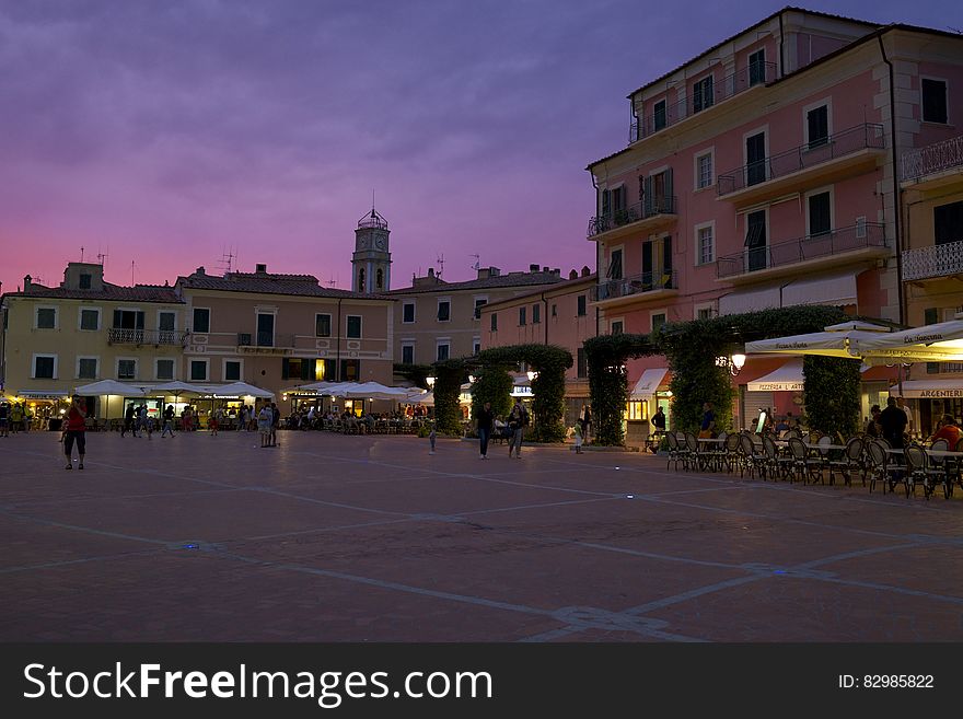 Outdoor restaurants in piazza in Italy at sunset.
