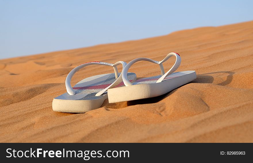 Sandals on desert sand on sunny day. Sandals on desert sand on sunny day.