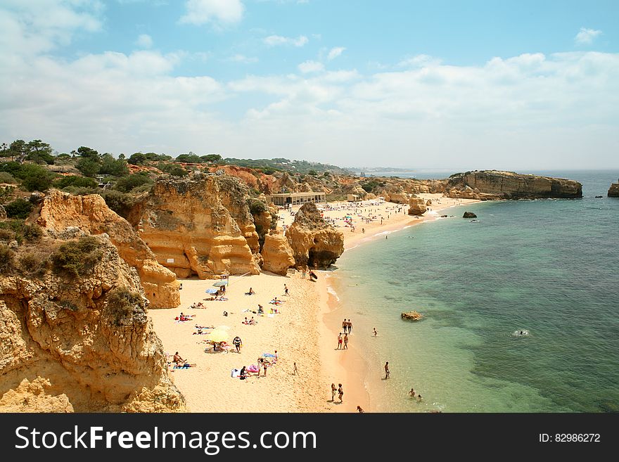 Aerial view of tourists on sandy coastal beach on sunny day. Aerial view of tourists on sandy coastal beach on sunny day.