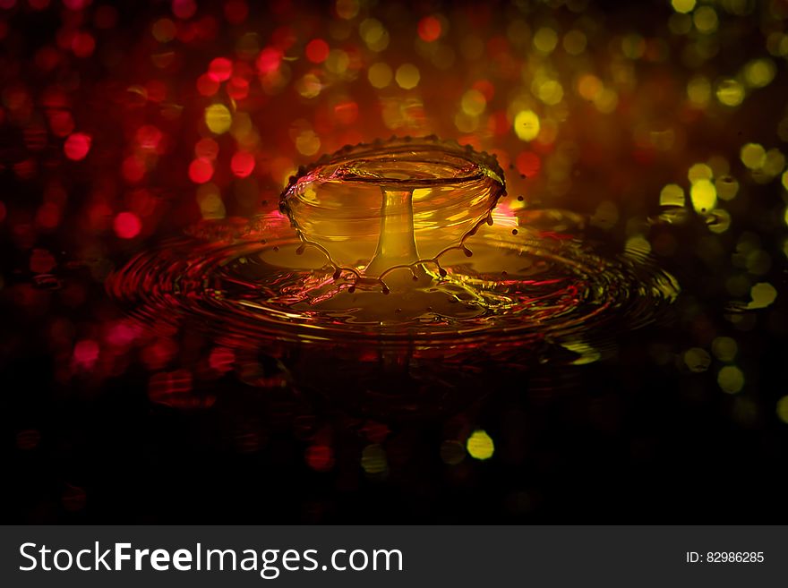 Water drop splashing and creating ripples with bokeh light background. Water drop splashing and creating ripples with bokeh light background.