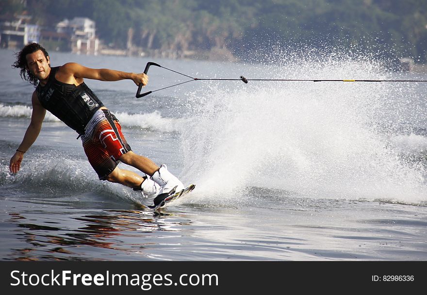 Man in Black Tank Top and Red Shorts Waveboarding