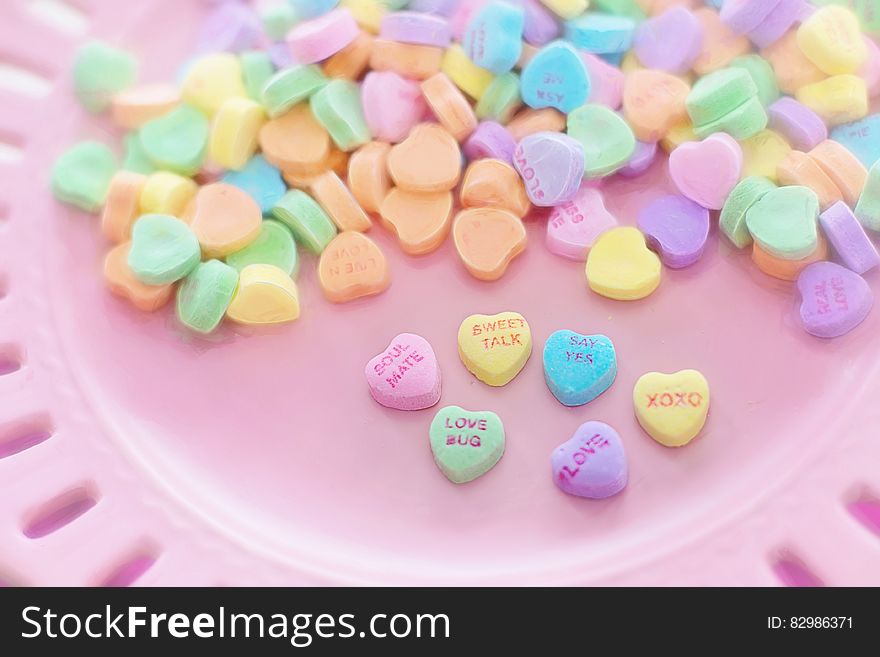 Valentine's Day heart candies on pink plate. Valentine's Day heart candies on pink plate.