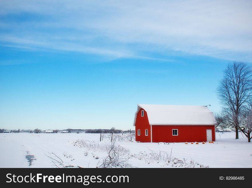 Red Barn House in the Middle of Snow Field During Daytime