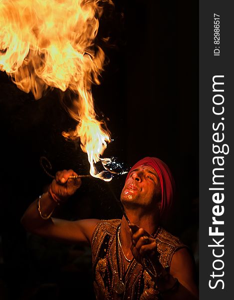 Man performing fire eating tricks against dark skies. Man performing fire eating tricks against dark skies.