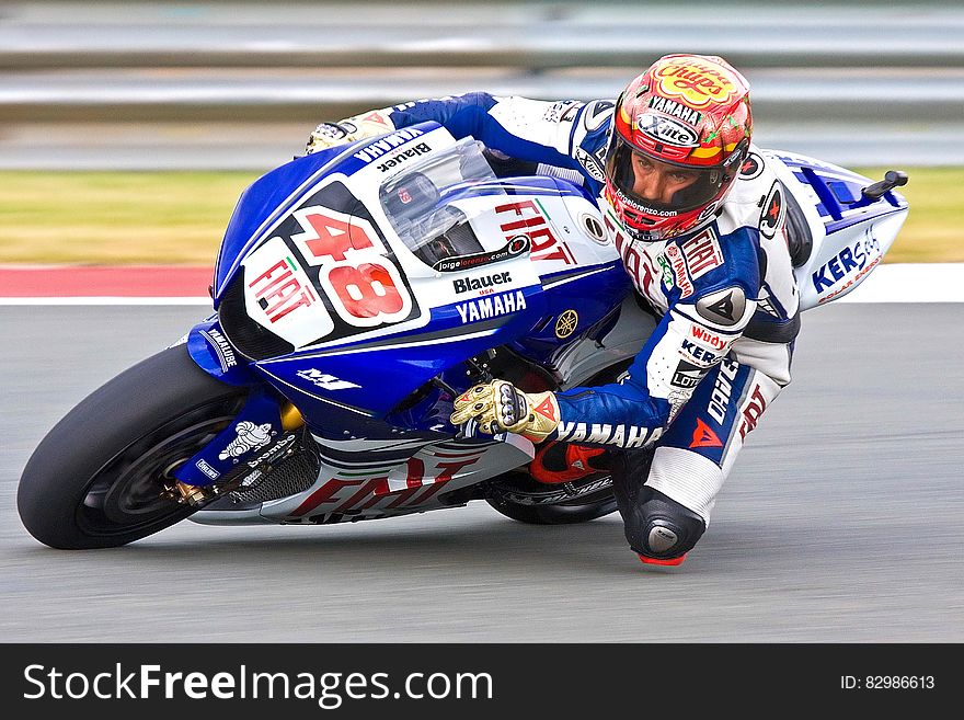 Competitor number 48 in motorbike race with bike covered by name of sponsoring companies using bike to advertise. Competitor number 48 in motorbike race with bike covered by name of sponsoring companies using bike to advertise.