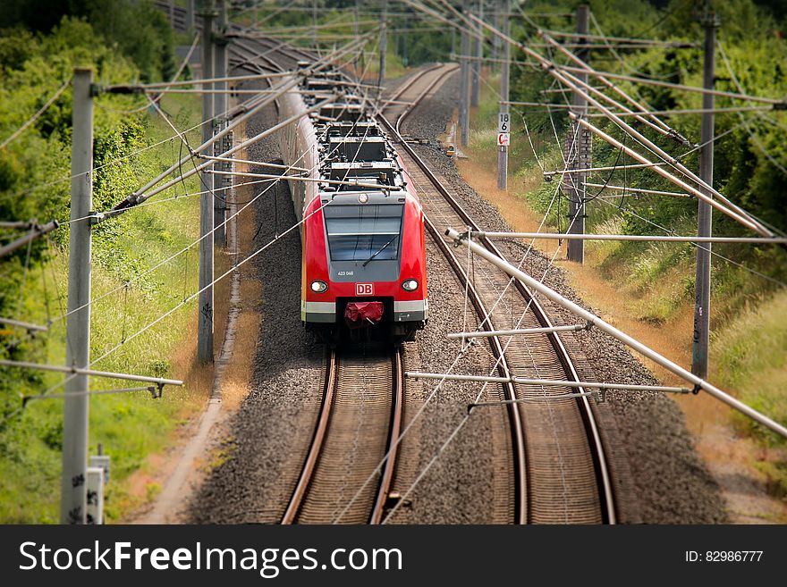 Electric train running on overhead lines on track through woods. Electric train running on overhead lines on track through woods.