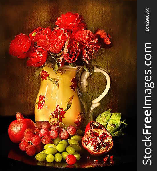 Red Petaled Flowers in White Red Floral Ceramic Vase Beside Red and Green Grapes