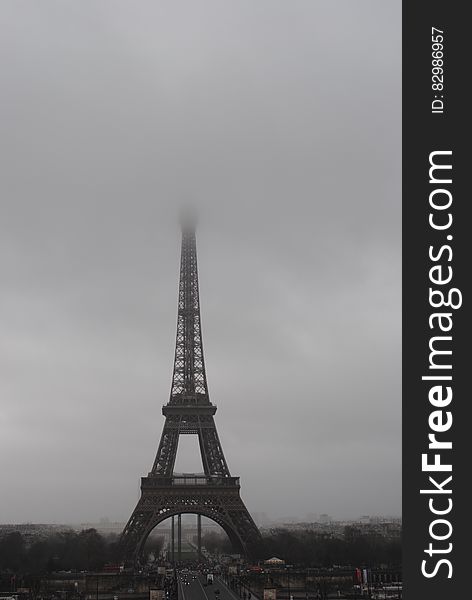 Monochrome view of Eiffel tower in Paris on foggy day, France.