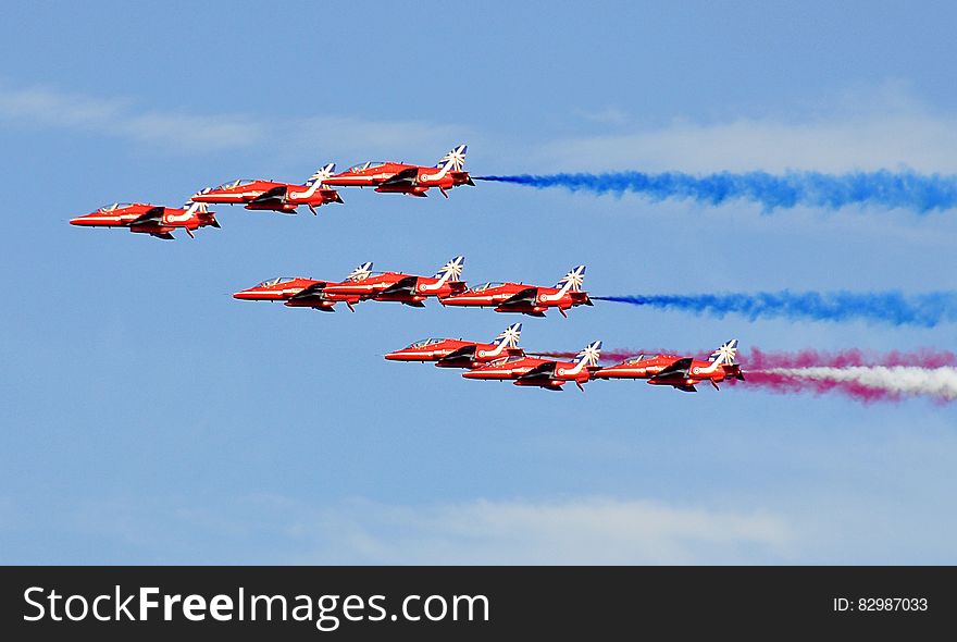 Red Jet Fighter Planes With Assorted Colors of Smoke on Horizon