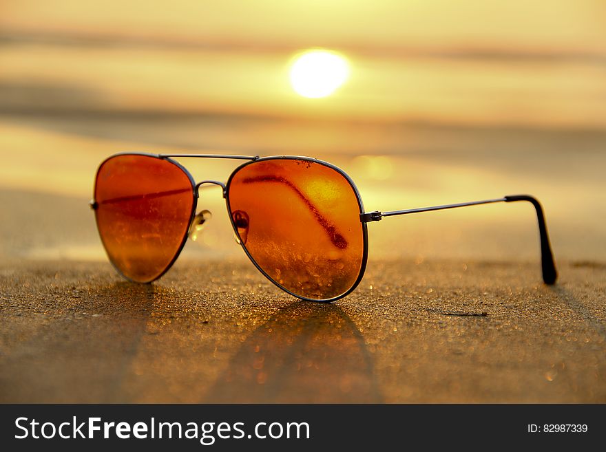 Sunglasses on sandy beach at sunset. Sunglasses on sandy beach at sunset.