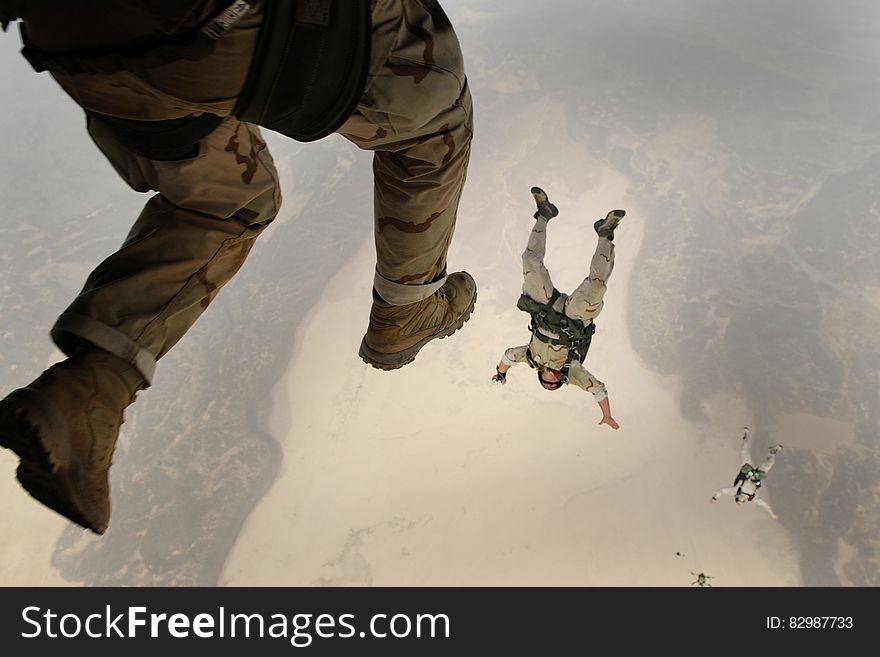 A group of paratroopers jumping off the plane.