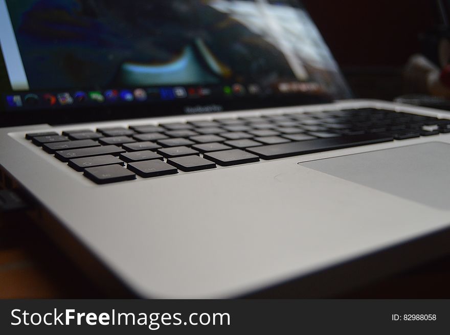Closeup of light gray laptop computer with selective focus on keys, dark background. Closeup of light gray laptop computer with selective focus on keys, dark background.
