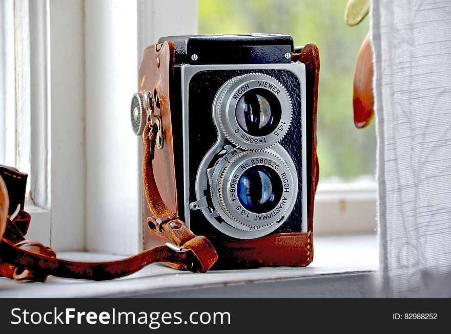 Vintage twin lens reflex camera on a window sill.