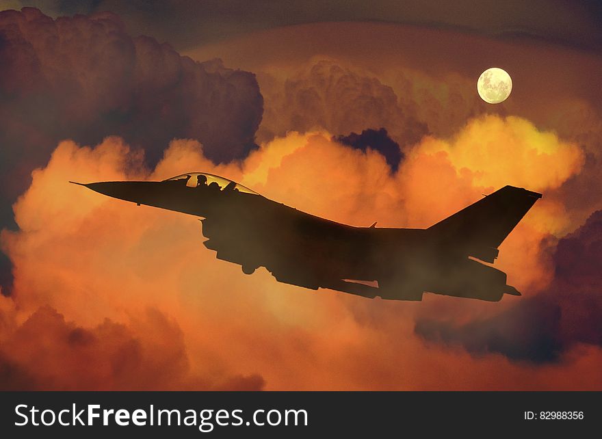 Silhouette Of Fighter Plane Flying Through Clouds