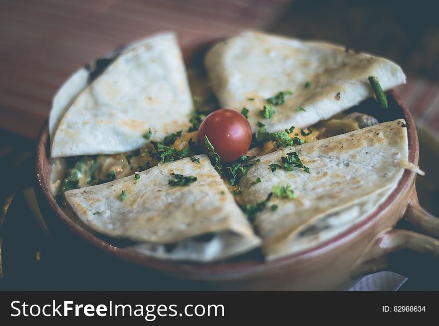 Four Mexican quesadillas on a clay pot.