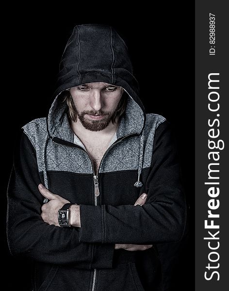 Studio portrait of man in hoodie jacket with serious expression.