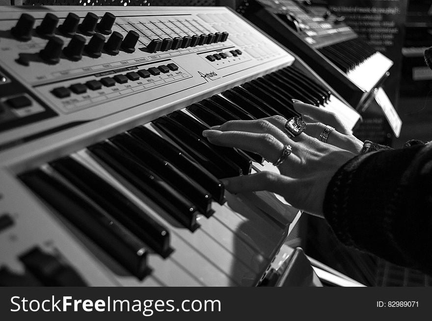 Person Playing Electric Piano In Grayscale Photo