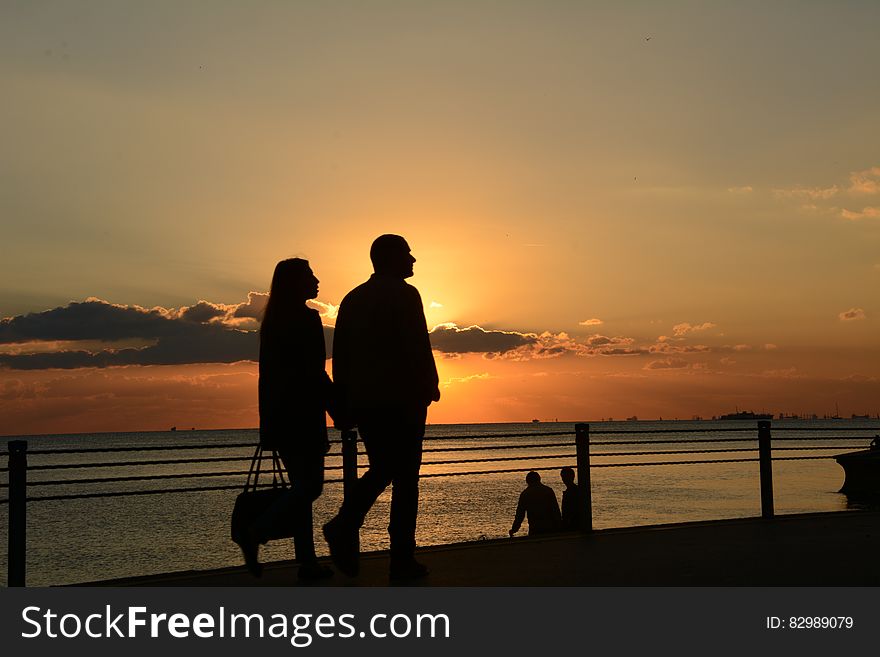 Man and Woman Silhouette Walking during Sunset