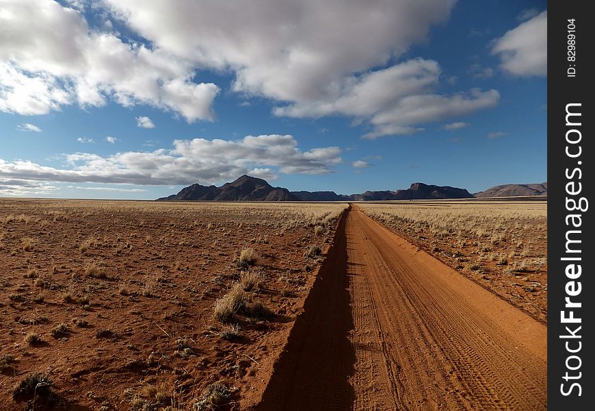 Brown Sandy Field Under Blue And White Cloudy Sky