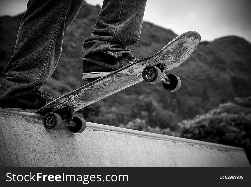 Close up of skateboarder on edge of concrete ramp in black and white. Close up of skateboarder on edge of concrete ramp in black and white.