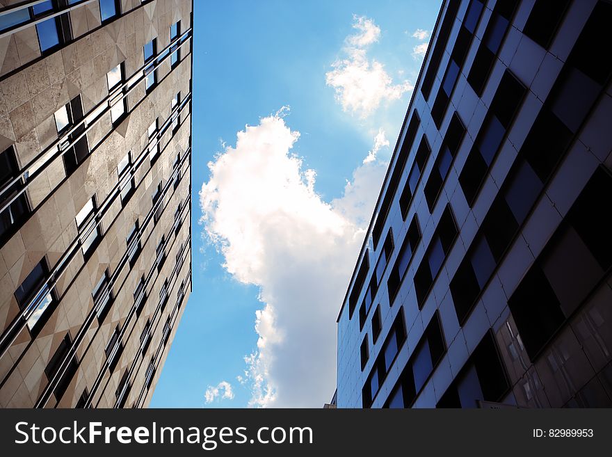 Facade of high rise buildings against blue skies on sunny day.