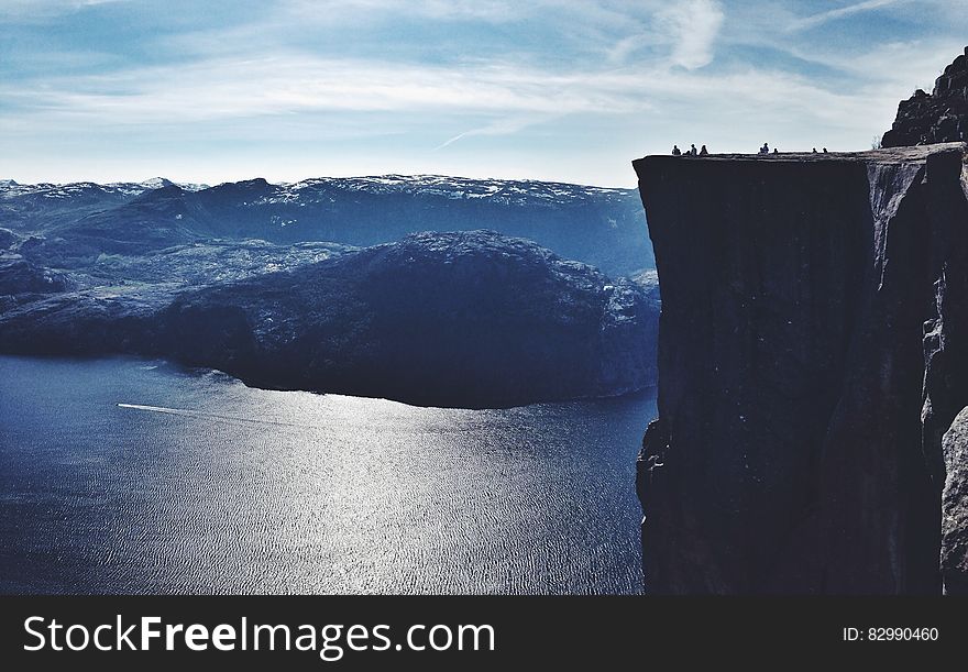 Observation deck on cliff over blue waters of alpine lake on sunny day. Observation deck on cliff over blue waters of alpine lake on sunny day.