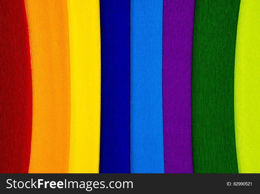 Abstract textured background of colorful vertical strips including red, orange, yellow dark blue, light blue, purple, green, lime. Abstract textured background of colorful vertical strips including red, orange, yellow dark blue, light blue, purple, green, lime.