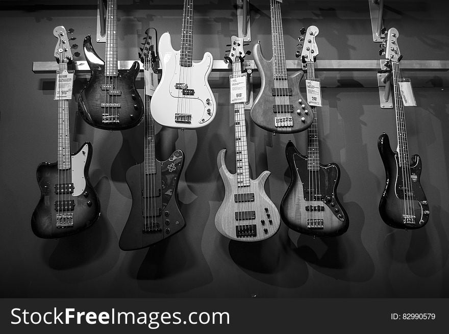 8 Electric Guitars Hanged on Brown Steel Bar