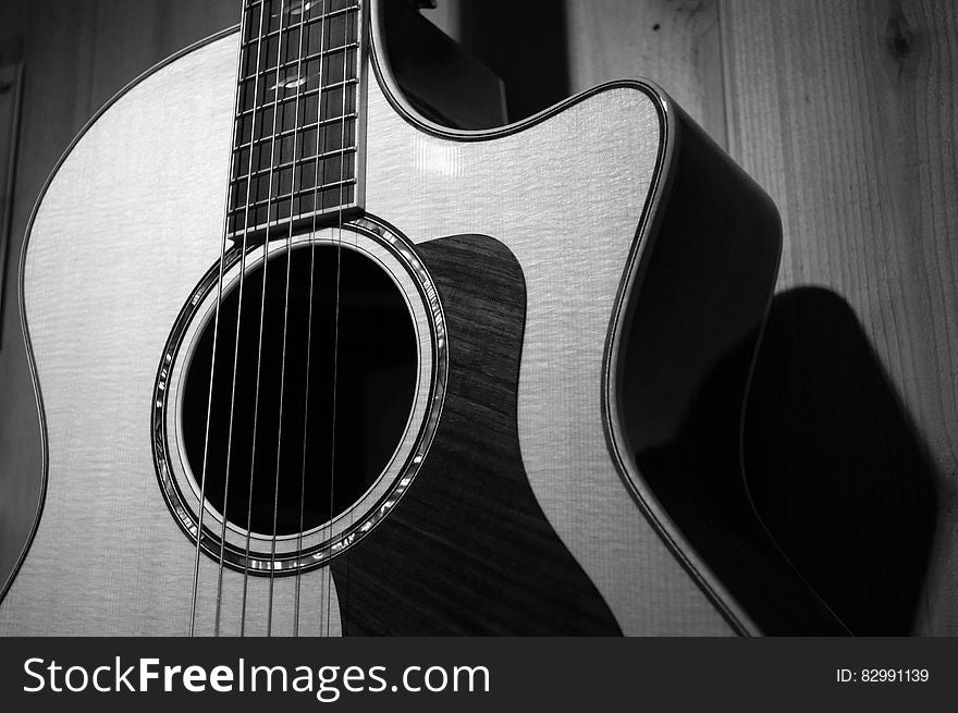 Acoustic Guitar In Grayscale Photo