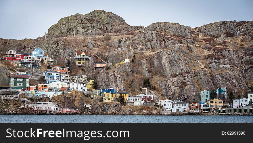 Colorful houses on rocky hillside along waterfront of St. John's, Newfoundland, Canada on sunny day. Colorful houses on rocky hillside along waterfront of St. John's, Newfoundland, Canada on sunny day.