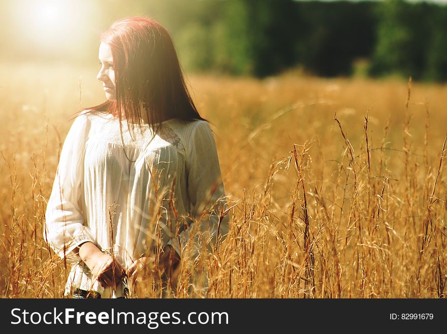 Woman Wearing White Long Sleeved Shirt Standing in Brown Grass Field