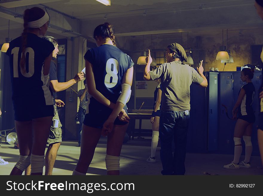 Indoor meeting in locker room of teens wearing numbered jerseys. Indoor meeting in locker room of teens wearing numbered jerseys.