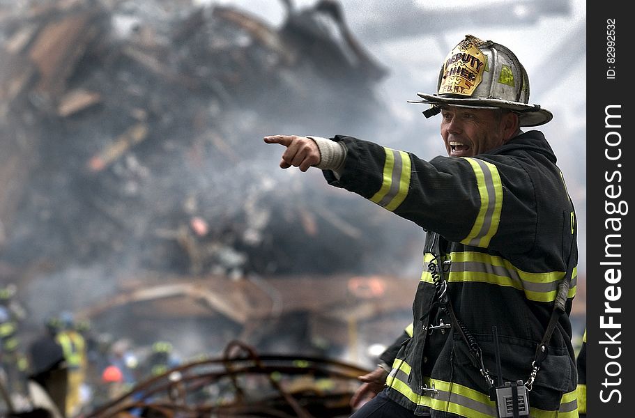 Fire Fighter Wearing Black And Yellow Uniform Pointing For Something