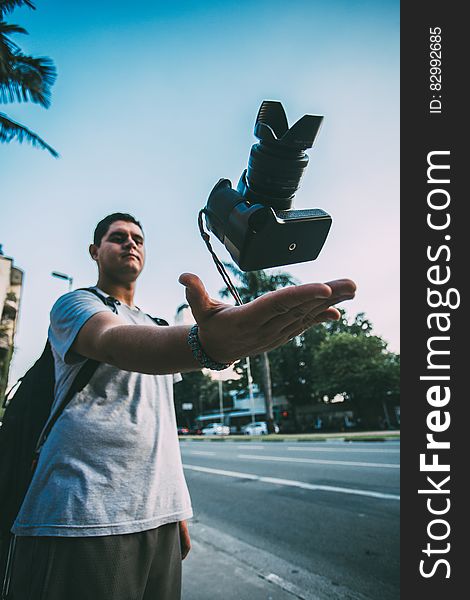 Man Throwing Black Camera In Air