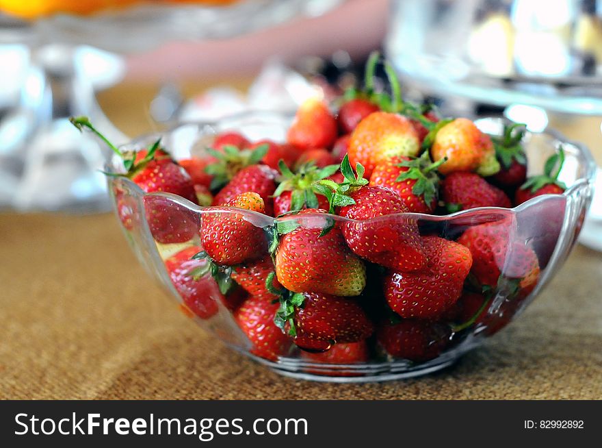 Red Strawberries in Clear Glass Bowl on Brown and Gray Textile