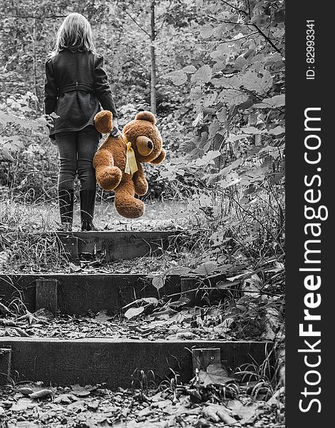 Girl in Jacket Carrying Brown Bear Plush Toy Selective Color Photo