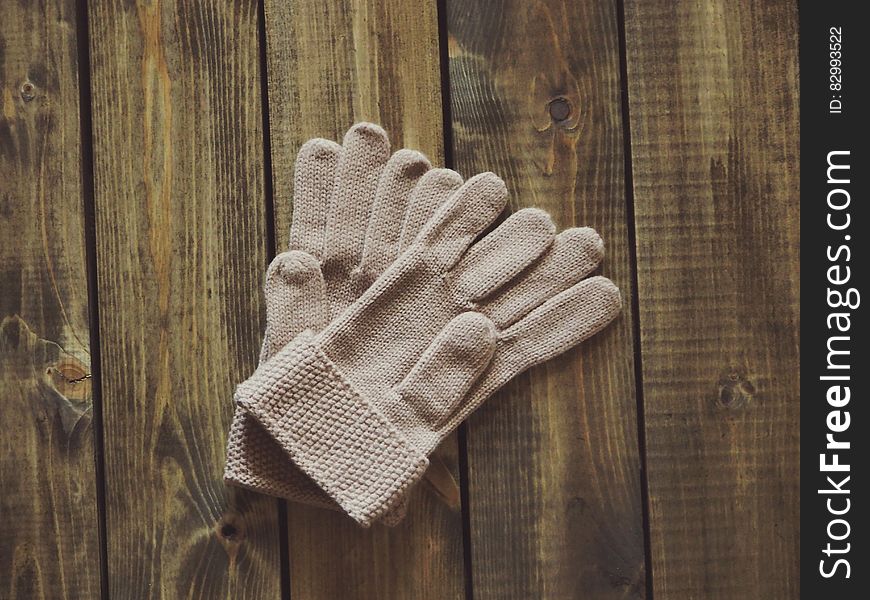 White Gloves on Brown Wooden Surface