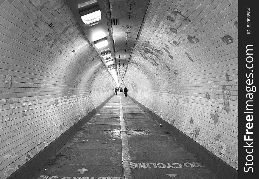 Silhouette of people walking through urban tunnel. Silhouette of people walking through urban tunnel.