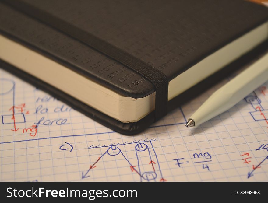 Leather book on page of diagrams and calculations with pen. Leather book on page of diagrams and calculations with pen.