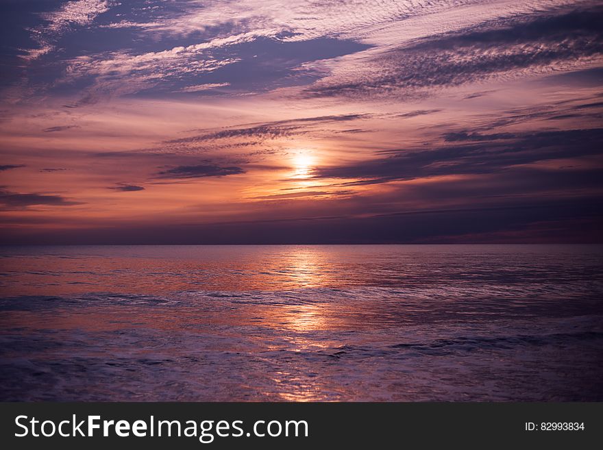Sunset over waves on ocean