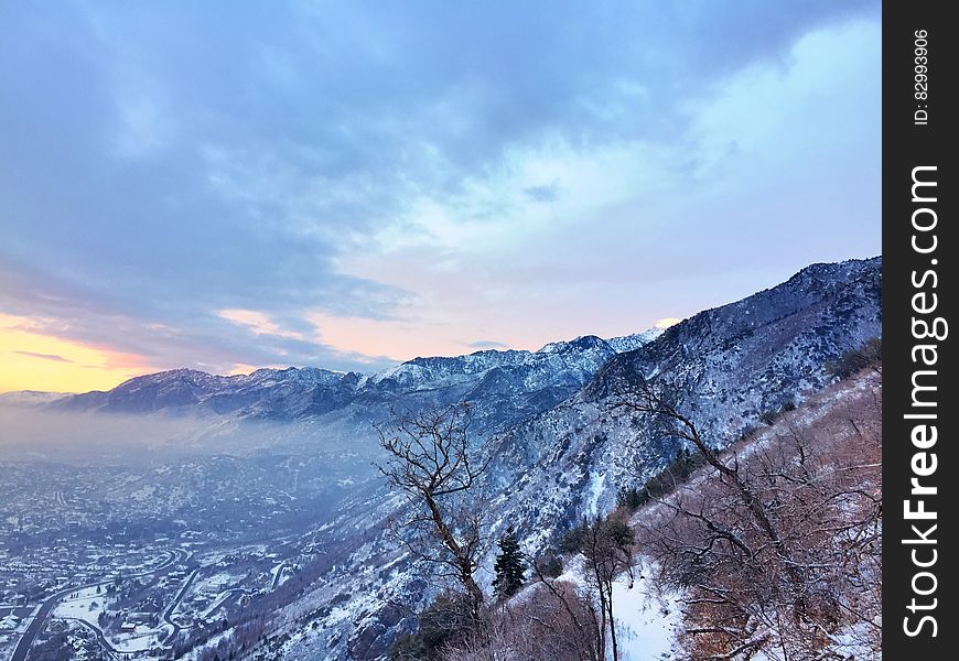 A view over a valley with a mountain range under snow cover. A view over a valley with a mountain range under snow cover.