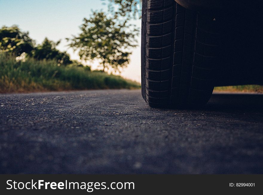 A close up of a car tire on an asphalt road. A close up of a car tire on an asphalt road.