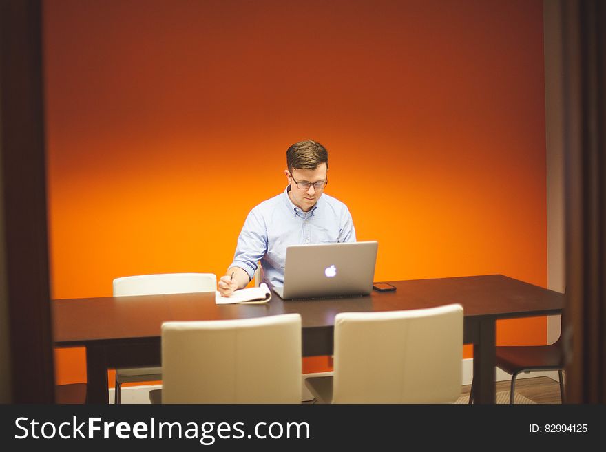 A man using a laptop computer on a desk. A man using a laptop computer on a desk.