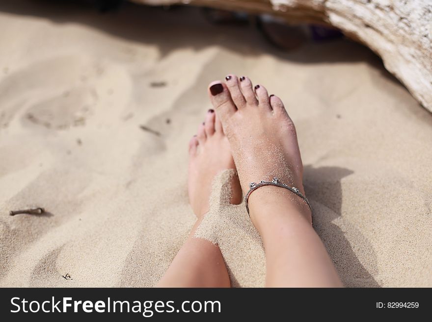 Human Feet on White Sand during Daytime
