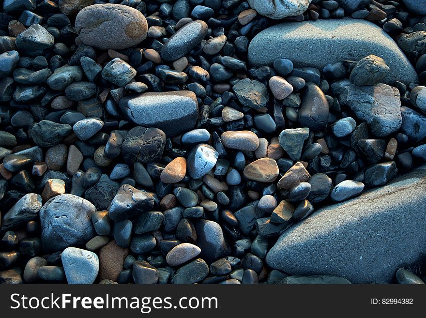 Close up of various pebbles on sunny day.