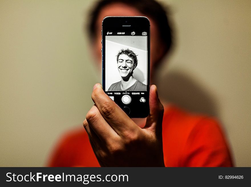 Man in Red Shirt Having Selfie on His Iphone in Grayscale Mode